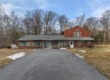 Front exterior of country home for sale at 133 Fort Henry Road in Bethel Pennsylvania with long driveway and wooded setting